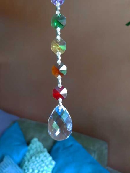 Kristal hanger '' druppel / ovaal '' met vrolijke chakra steentjes, ze straalt prachtige regenboogkleuren in een ruimte + chakra beschrijving