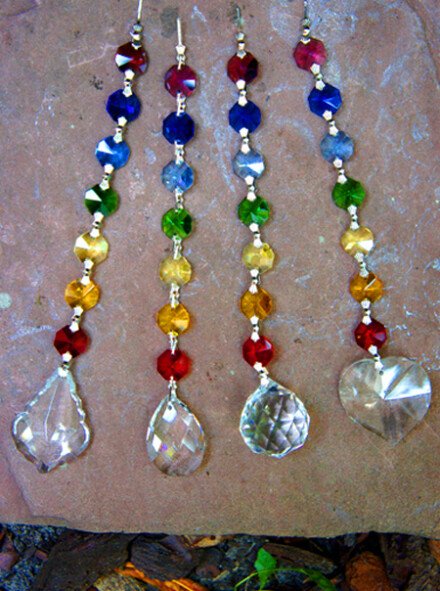 4 feng shui chakra kristal hangers die regenboogkleuren laten stralen als er zonlicht doorheen schijnt + chakra beschrijving