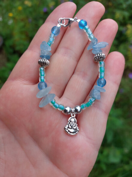 Armband met aquamarijn met Happy Boeddha bedel, kalmeert je en helpt mee je beter in de flow van het leven te komen + zakje