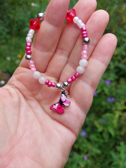Kinder armband op maat gemaakt met rozenkwarts met roze kralen + vlinder bedel + organza zakje
